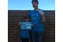 Eight-year-old Dominic Leah shows off his Swim a mile in a month Badge with mum Kate Leah