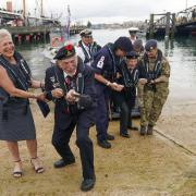 File photo dated 06/06/21 of D-Day veteran Joe Cattini raising his walking stick like a machine gun as he and other veterans are welcomed to the Portsmouth Historic Dockyard to commemorate the 77th anniversary of the Normandy Landings.