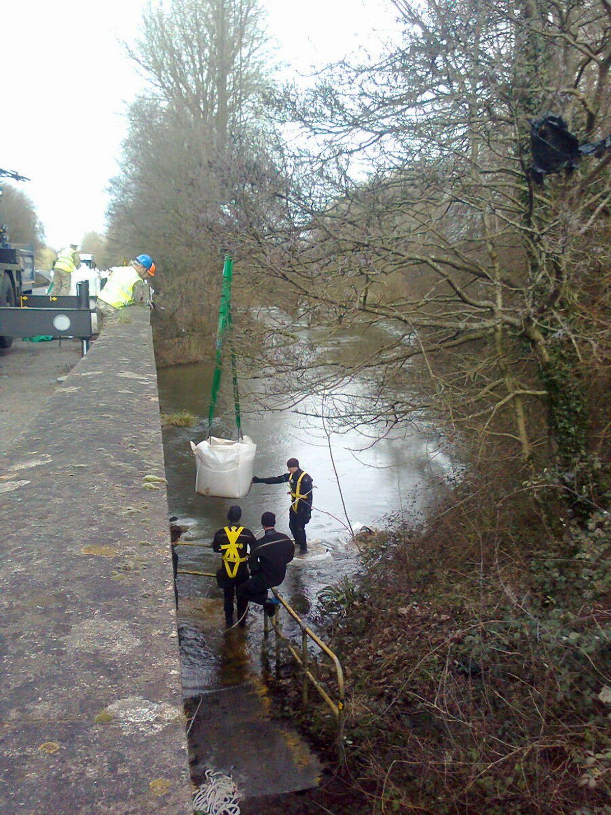 Royal Engineers unloading more than 100 bags into the Itchen at Kings Worthy