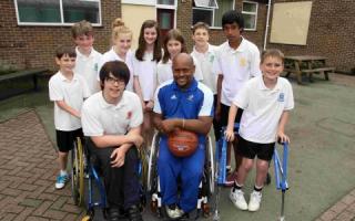Wheelchair basketball star Sinclair Thomas with pupils from Kings' School
