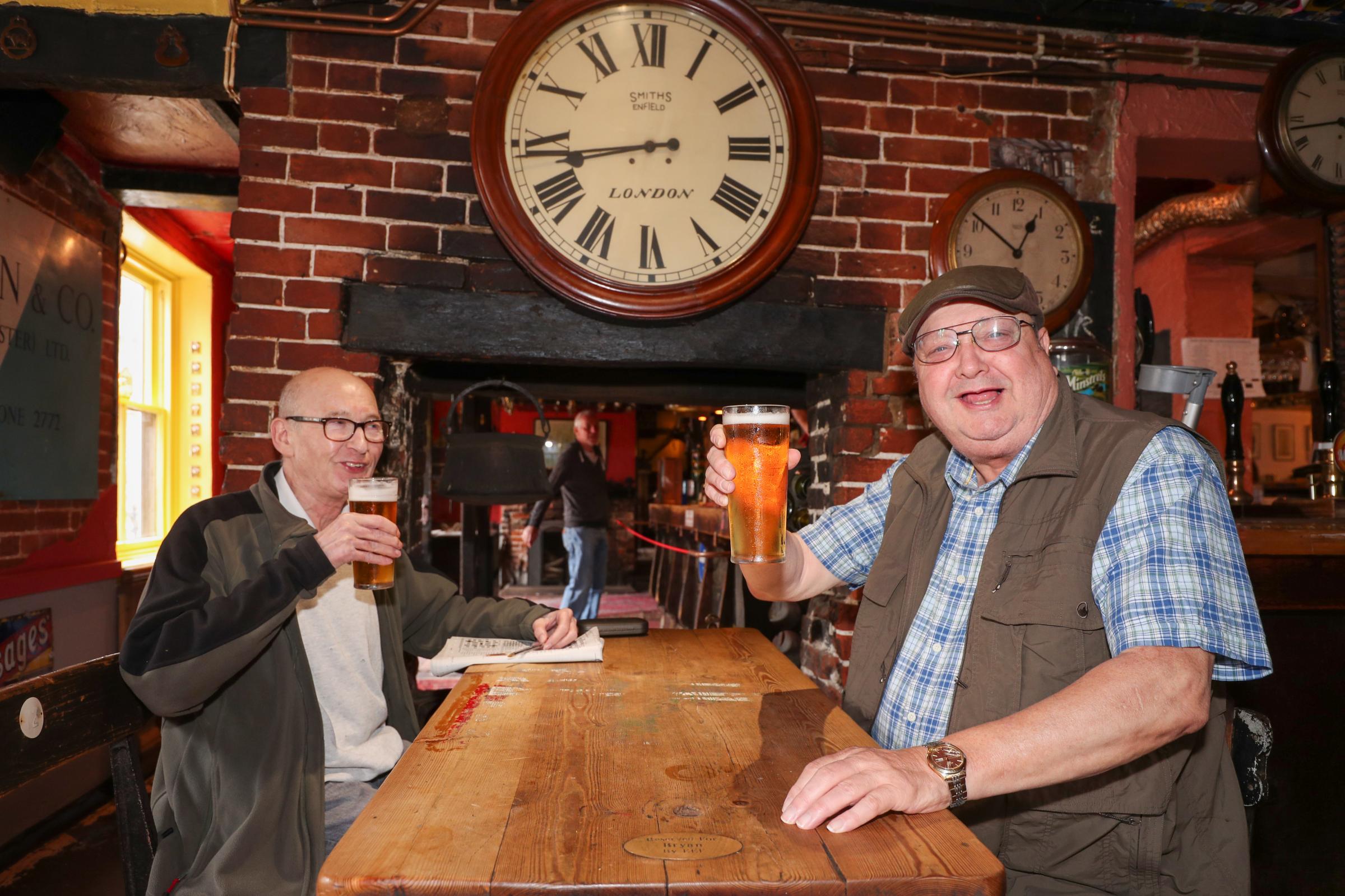 Pub and cafes reopen in Winchester after coronavirus restrictions were relaxed on Saturday 4th July. Patrick Broomfield and Mike Glass enjoy a pint and a chat in the Black Boy pub..