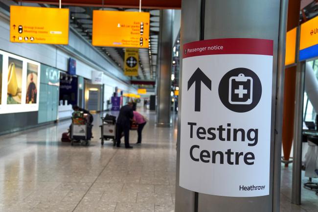 A sign directs passengers to a testing centre at Heathrow Airport