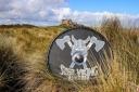 A steel Viking Shield infront of Bamburgh