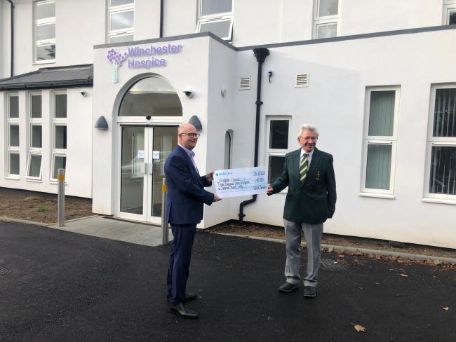 Francis Sheath, Captain of South Winchester Gold Club Seniors Section, presents the £3,912 cheque to Mark Jones, HHFT Head of Charity, outside Winchester Hospice