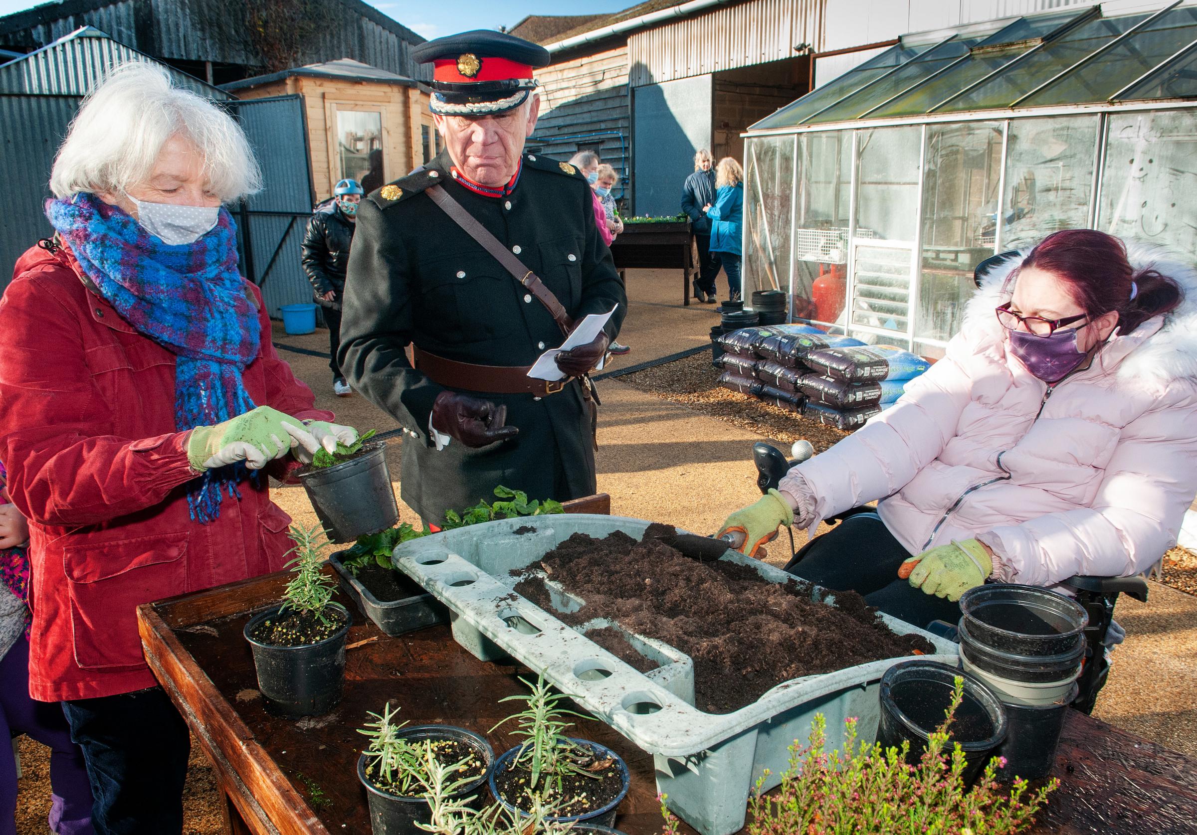 Hampshire Deputy Lord-Lieutenant Andrew Kent chats to member Beth and volunteer Kate over the new potting table