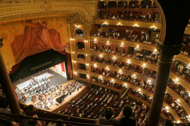 Hampshire Chronicle: A grand theatre with people watching an orchestra. Credit: Canva