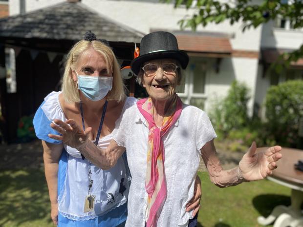 Hampshire Chronicle: St Catherines View Clinical Lead Hayley Geddes, who dressed up as Alice in Wonderland, is joined by resident Christina Millest at the home’s tenth anniversary party.