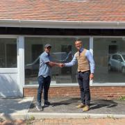 New shop owner Rajeev Sangroula (left) shaking hands with Jon Baud (right) from Trinity Rose