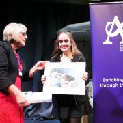 Jodie Clark being presented with a framed print of her painting by Chair of The Arts Society Winchester Sarah Hill
