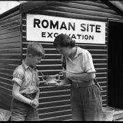 Miss A Bennet-Clark examining a two-handled 2nd century find at the dig in Middle Brook Street, with a volunteer from Pilgrims' School, August 1953