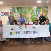Naomi House and Jacksplace care team and children holding CQC Outstanding banner